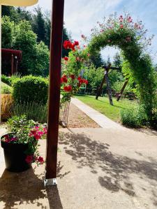 a garden with an arch with flowers and a pole at Apartman Korina in Otočac