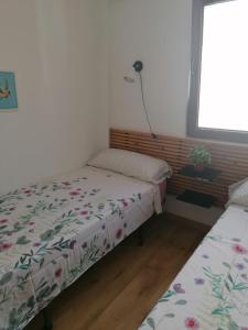 2 camas individuales en una habitación con ventana en Malvarrosa apartamentos, en Valencia