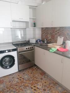 a kitchen with a stove and a washing machine at Malvarrosa apartamentos in Valencia