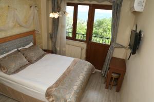 a bedroom with a bed and a television and a window at Seahouse Suites in Istanbul