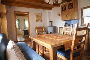 eine Küche und ein Esszimmer mit einem Holztisch und Stühlen in der Unterkunft Kellerstöckl Weinberg in Eisenberg an der Pinka