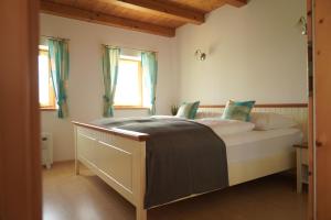 Schlafzimmer mit einem Bett mit weißer Bettwäsche und blauen Kissen in der Unterkunft Kellerstöckl Weinberg in Eisenberg an der Pinka