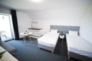 a bedroom with two beds and a table and a window at WILLA ILONA 1 in Łeba