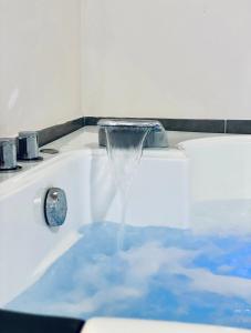 a bath tub filled with blue water with a faucet at Green room in Marathopolis