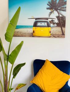 a yellow car on the beach with a surfboard at Green room in Marathopolis