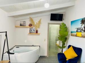 a bathroom with a white tub and a tv on the wall at Green room in Marathopolis