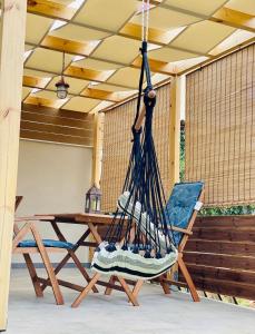 a swing in a porch with a table and a chair at Green room in Marathopoli