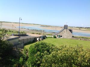 a building with a beach in the background at Le Caribou d'Eva in Portbail