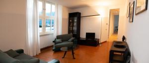 a living room with a couch and chairs and a television at Little Marina Apartment in Malgrate