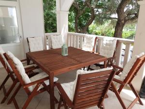een houten tafel en stoelen op een veranda bij Apartments Costa Rica in Orebić