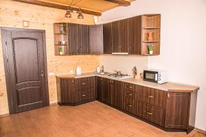 a kitchen with wooden cabinets and a microwave at Мигово Гражда in Migovo