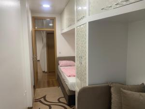 a small bedroom with a bunk bed and a couch at Apartment Poturmahala in Travnik