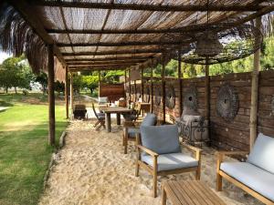 a patio with chairs and tables under a pergola at Ponte Pedra - Melides Country House Adults Only in Melides