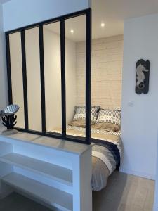 a bedroom with a bed with a mirror at Bâbord in La Flotte