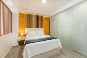 um quarto com uma cama e uma parede de vidro em LA TRINIDAD SUITES em Fuengirola