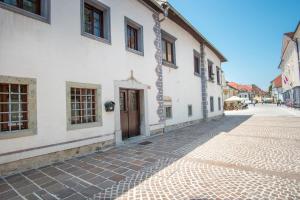 a cobblestone street in front of a white building at Vila Radolca apartments & rooms in Radovljica