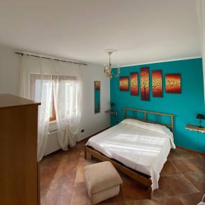 ベルヴェデーレ・マリッティモにあるB&B La Torreの青い壁のベッドルーム1室(ベッド1台付)