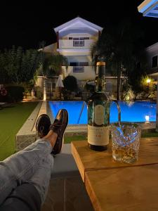 een fles wijn zittend op een tafel met een glas bij Oscar Villa & Studios in Alykes