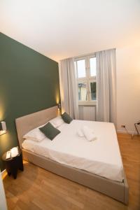 una camera da letto con un grande letto bianco e una finestra di Little Marina Apartment a Malgrate