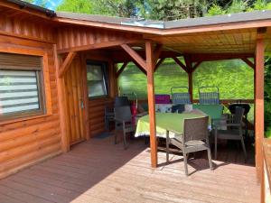 a wooden deck with a table and chairs on it at Zefir Domek nr 5 in Dąbki