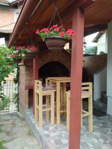 un patio con mesa, sillas y una maceta de flores en Apartment Dil, en Kulen Vakuf