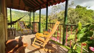 une terrasse couverte avec des fauteuils à bascule et une vue sur les montagnes. dans l'établissement La Acuarela, Posada de La Monita, à Pereira