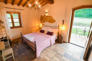 um quarto com uma cama e uma grande janela em Agriturismo Poggio Ridulfo em Volterra