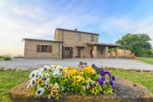 una casa con un mazzo di fiori davanti di Agriturismo Poggio Ridulfo a Volterra