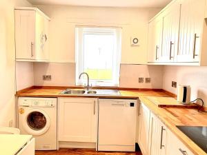 a kitchen with a sink and a washing machine at Sea View in Ardrossan