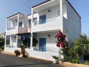 a white building with flowers in front of it at Studio Mare in Megalochori