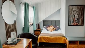 um quarto com uma cama, uma escrivaninha e uma cadeira em Browar Osjann - pokoje gościnne em Biała Podlaska
