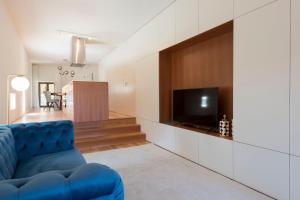 un soggiorno con divano blu e TV di Magnificient 2BR Duplex w/ Gorgeous View by LovelyStay a Porto