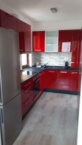 a kitchen with red cabinets and a stainless steel refrigerator at Apartment in Balatonalmadi 36663 in Balatonalmádi