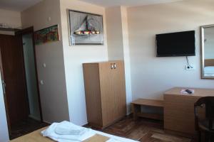Una habitación de hotel con una cama y un televisor en la pared. en Kadikoy Otel, en Estambul