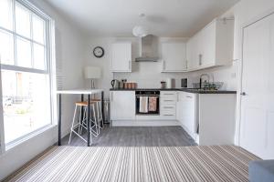 eine Küche mit weißen Schränken und einem Herd mit Backofen in der Unterkunft The Teapot Cottage in Town Centre FREE Parking in Stratford-upon-Avon