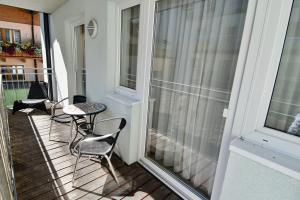 balkon z krzesłami, stołem i oknem w obiekcie Yako Apartment - Wagrain Center w mieście Wagrain +18 zdjęć