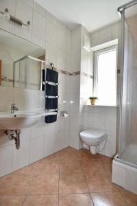 biała łazienka z umywalką i toaletą w obiekcie Yako Apartment - Wagrain Center w mieście Wagrain