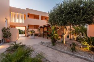 a building with a courtyard with trees and plants at Cirillo Family Hotel-Christinas Studios in Mastihari