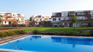 a swimming pool in front of some apartment buildings at Apartment in Balatonalmadi 36663 in Balatonalmádi
