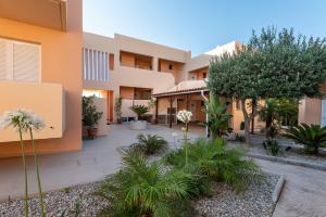 a courtyard of a building with trees and plants at Cirillo Family Hotel-Christinas Studios in Mastihari