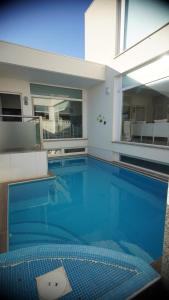 Una gran piscina con agua azul en un edificio. en Sea Soul Esposende, en Esposende