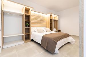 una camera con un grande letto e scaffali in legno di Albana Apartaments Turístics a L'Escala