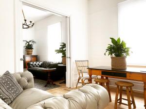 a living room with a couch and a table at Castlebar - Superior Boutique Accomodation - Steps to Pakington Street in Geelong West