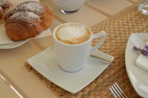 a cup of coffee on a table with pastries at B&B Fermata 106 da Carolina in Siculiana Marina