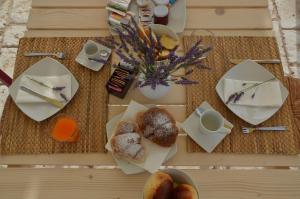 a table with plates of pastries and cups of coffee at B&B Fermata 106 da Carolina in Siculiana Marina