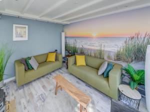 a living room with two couches and the beach at Comfortable vacation home near the sea in Noordwijkerhout