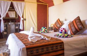 a bedroom with a bed with towels on it at Sahara Luxury Desert Camp in Merzouga