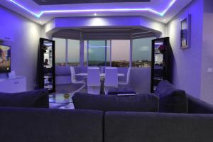 a living room with purple lighting and a couch at Nouveau appartement vue sur mèr , renouvelé en entier in Asilah