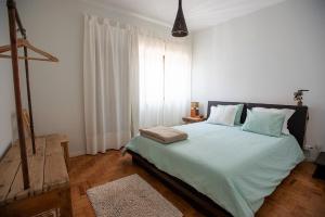 een slaapkamer met een bed en een groot raam bij Casa do Remo Praia da Aguda in Arcozelo