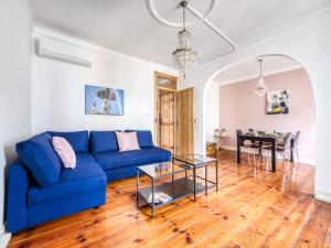 a living room with a blue couch and a table at Apartment in the heart of Lisbon in Lisbon